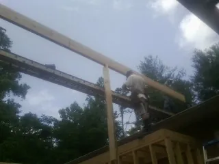 Carpenter setting a ridge beam over a new addition frame — Ice Dam Removal by Roofing Brothers in Nitro