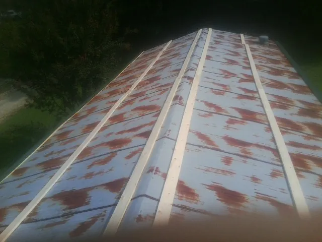 Rusted metal roof panels with new wood purlins before replacement — Storm Damage Roof Repair in Nitro by Roofing Brothers