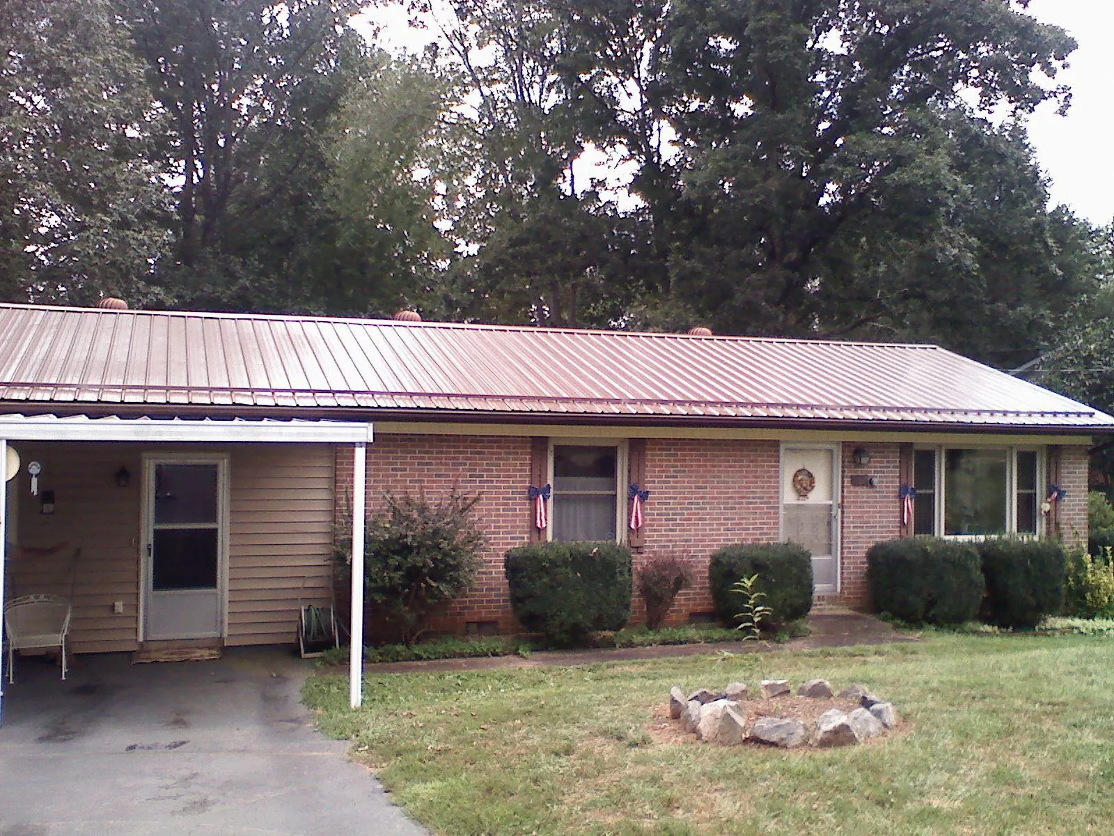 Bronze metal roof and carport on a brick ranch home — Roof Repair work by our crew in Nitro
