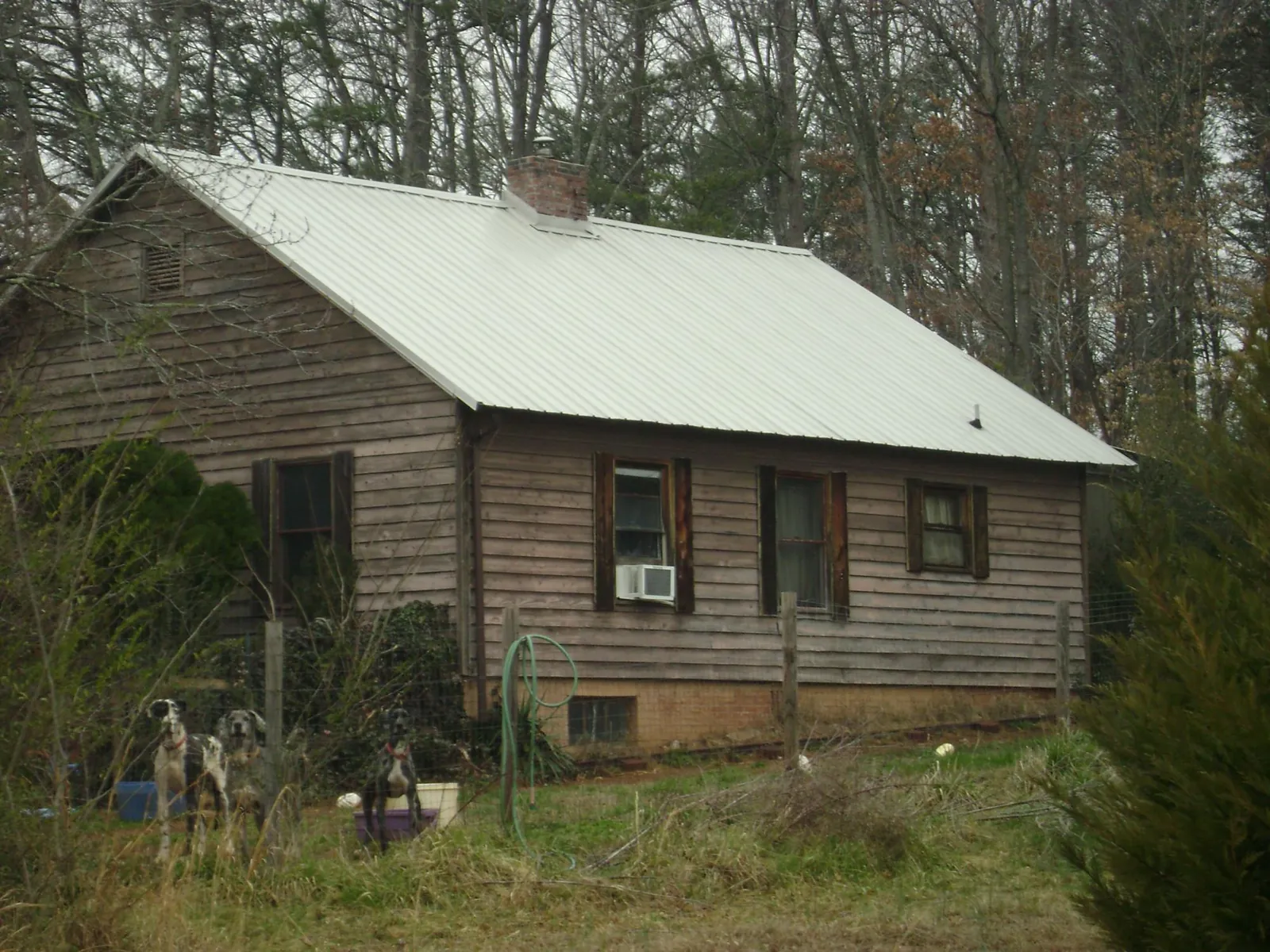 White metal roof on an old wood sided farmhouse, from a Metal Roof Installation job in Nitro